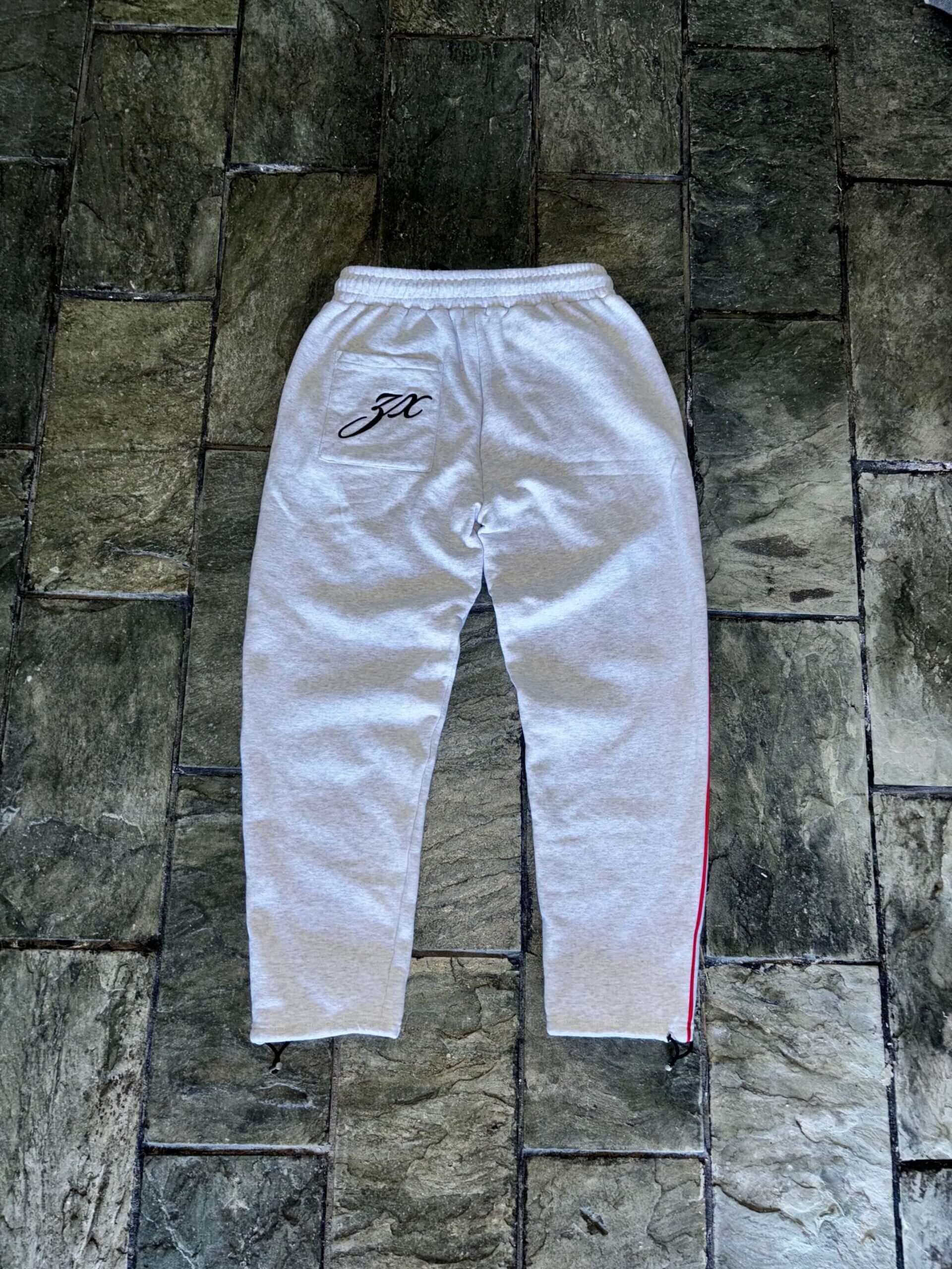 White slim-fit joggers featuring an embroidered logo and side stripes, perfect for casual styling and comfort.