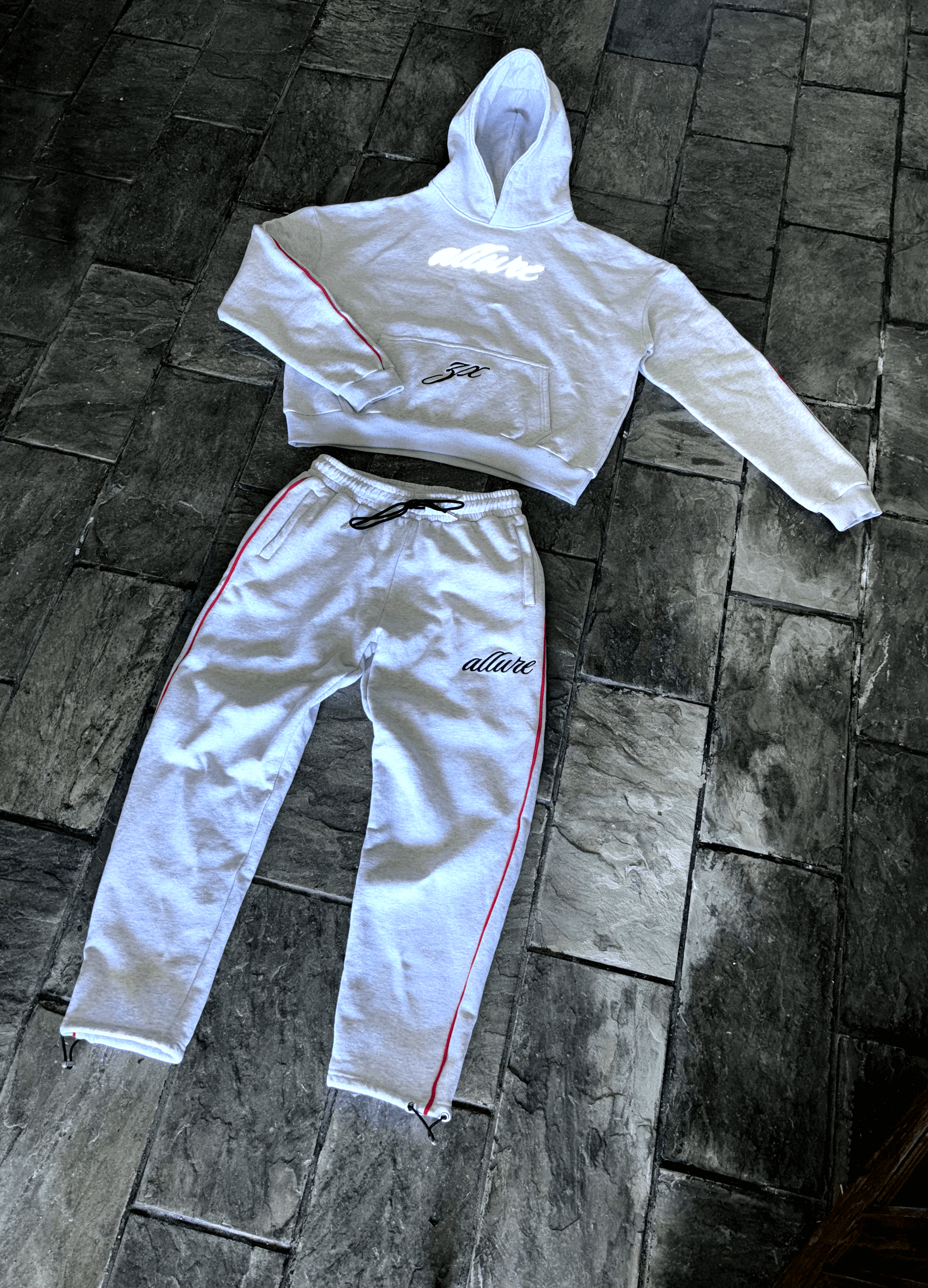 Allure Track Pants and hoodie set in grey cotton, featuring red stripes and a slim fit design, ideal for luxury tracksuit style.